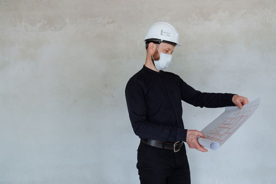 Un architecte, des plans et un bâtiment en intérieur